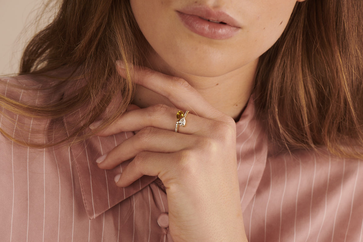 Deux – Yellow Sapphire ring in yellow gold worn on the hand, pink striped blouse